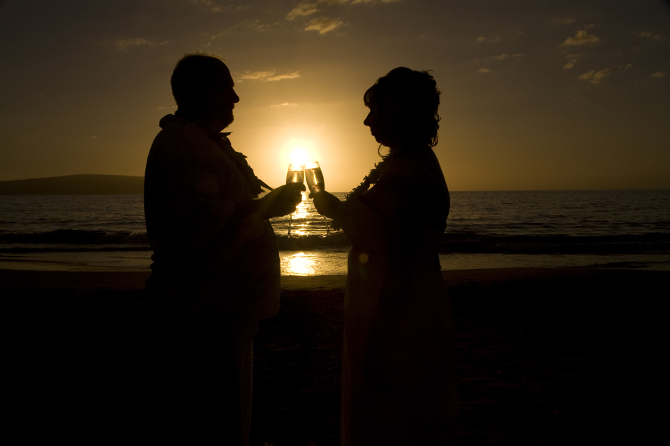 toasting champagne glasses as sunset